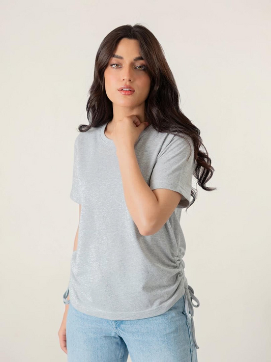 Model wearing Coastline's Arle Drawstring Side Top in Heather Grey, showing its short sleeves, relaxed fit and gathered side detailing.