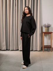 Angled view of the Brooklyn black co-ord set showing the boxy top and matching wide-leg trousers.