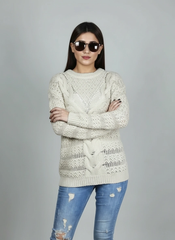 Model posing with folded arms in Coastline's Ivory Cable Knit Sweater, showing the cable-knit texture and fit.