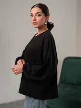 Model wearing Coastline's Cherie Top in Black, showing its relaxed silhouette and balloon sleeves with gathered cuffs.