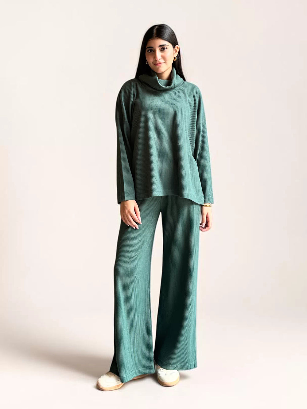 Model wearing Coastline’s Yula evergreen double-knit matching set with a high-neck top, long sleeves and wide-leg trousers.