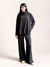 Model wearing Coastline’s Yula smoky black double-knit matching set with a high-neck top, long sleeves and wide-leg trousers.