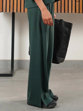 Side view of the Dazy Amazon Green wide-leg trousers showing the textured fabric and side slit near the hem.