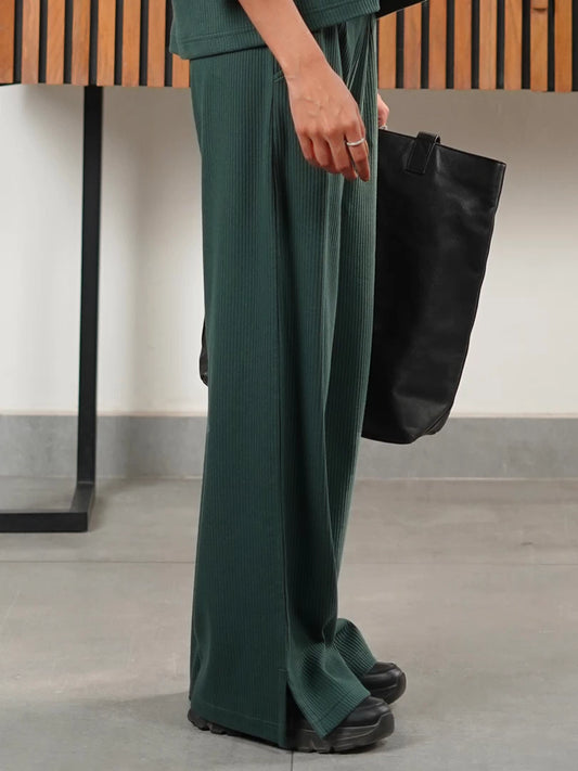 Side view of the Dazy Amazon Green wide-leg trousers showing the textured fabric and side slit near the hem.