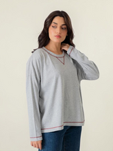 Model wearing Coastline's Esther Oversize Long Sleeve Top in Heather Grey, featuring a relaxed fit and contrast-trimmed V-neckline.