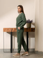 Side view of the Kiwi green sweatshirt and trouser set showing the long sleeves and trouser silhouette.