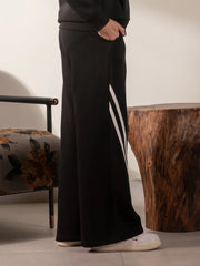 Side view of the Lana black fleece trousers showing the wide-leg silhouette and contrast stripe detail.