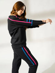 Side view of the Michi Black sweatshirt and trouser set, showing the colourful sleeve and trouser stripe details.