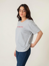 Model wearing Coastline's New York Tee in Heather Grey, featuring a red New York City chest print, crew neckline and short sleeves.
