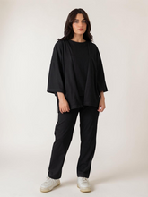 Front view of the Poppy black three-piece resort set showing the loose front-open overlayer, inner top and matching trousers.