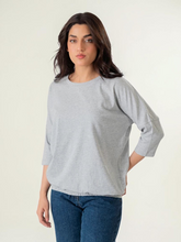 Model wearing Coastline's Rylee Batwing Sleeve Top in Heather Grey, showing its loose batwing sleeves and gathered elasticated hem.