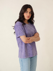 Front view of the Sage Purple oversized cotton tee with a mineral-washed finish, worn by a model with folded arms.