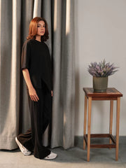 Angled view of the Sorelle black summer co-ord set showing the oversized top and flowing wide-leg trousers.