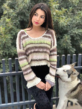 Model wearing Coastline's Cropped Multicolor Sweater with striped multicolor knit, styled with black trousers outdoors.