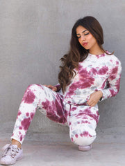 Seated model wearing the Ocean Drive Purple two-piece tie dye set with a long-sleeve top and matching trousers