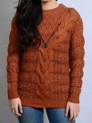 Person wearing a brown knitted sweater with a pattern on a plain background