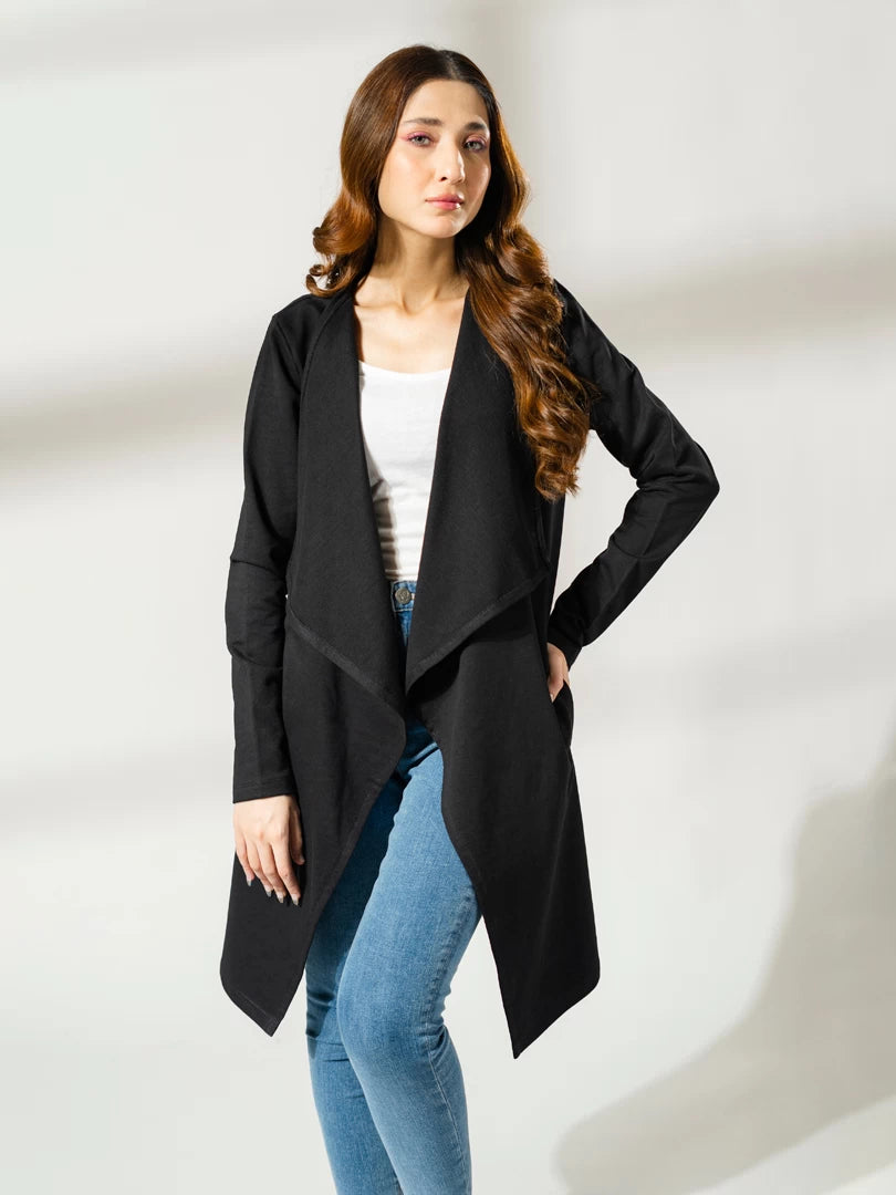 Front view of the Ashley black draped overlayer showing its open front and pointed hem, styled with a white top and blue jeans.
