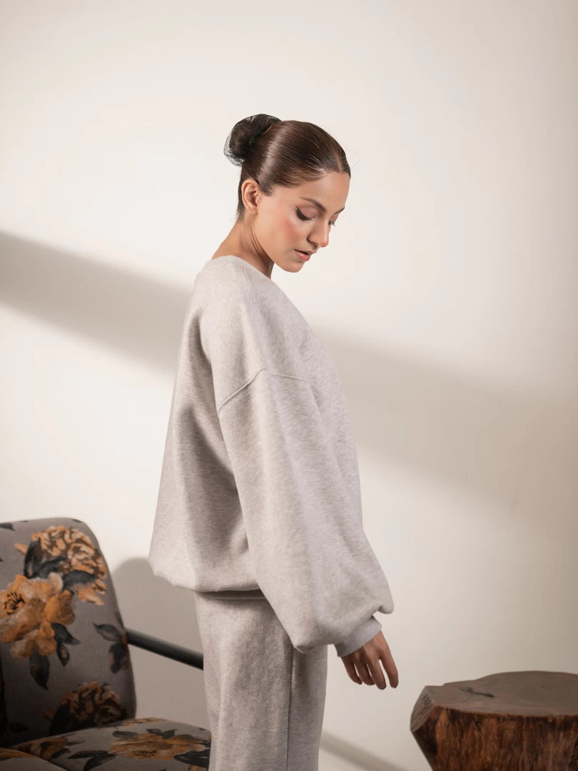 Side view of the Barlow Heather Grey sweatshirt highlighting its oversized body, dropped shoulders and balloon sleeve shape.