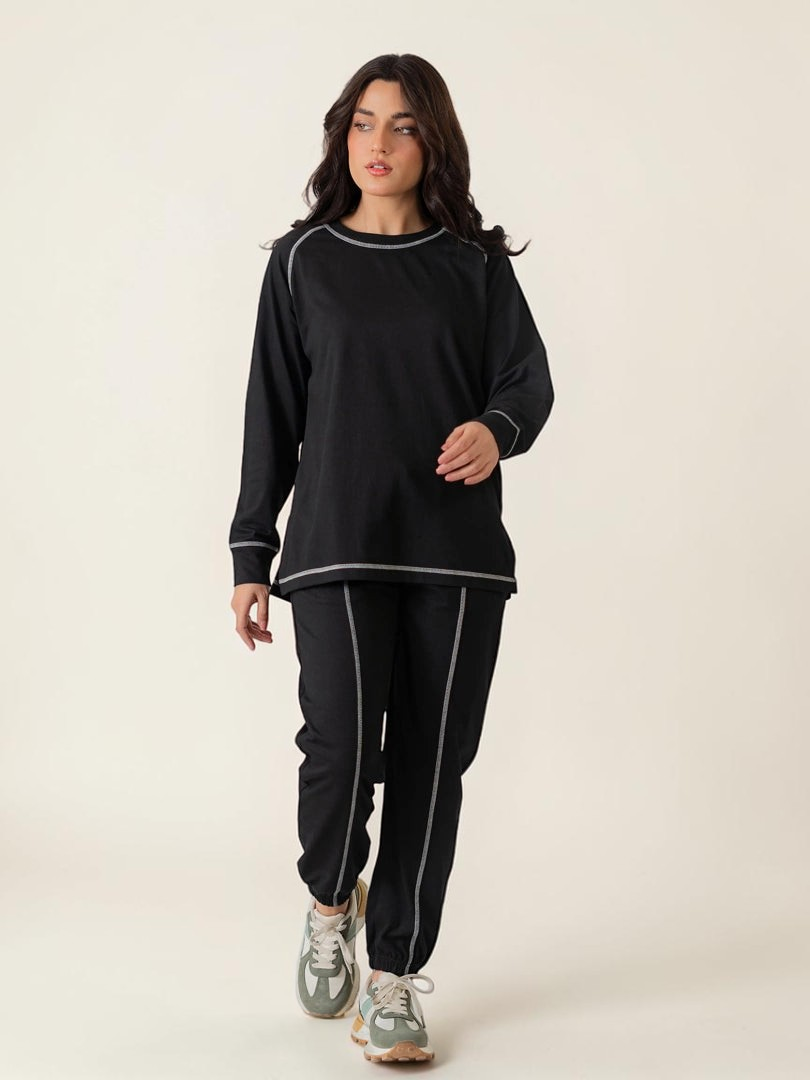 Full-length front view of the Berlin Black matching set showing the relaxed top and coordinated trousers with contrast stitching.