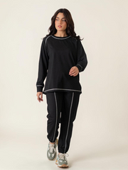 Full-length front view of the Berlin Black matching set showing the relaxed top and coordinated trousers with contrast stitching.