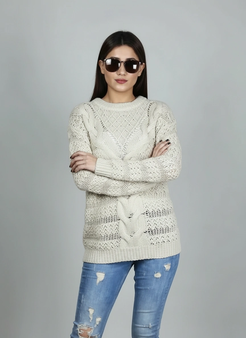 Model posing with folded arms in Coastline's Ivory Cable Knit Sweater, showing the cable-knit texture and fit.