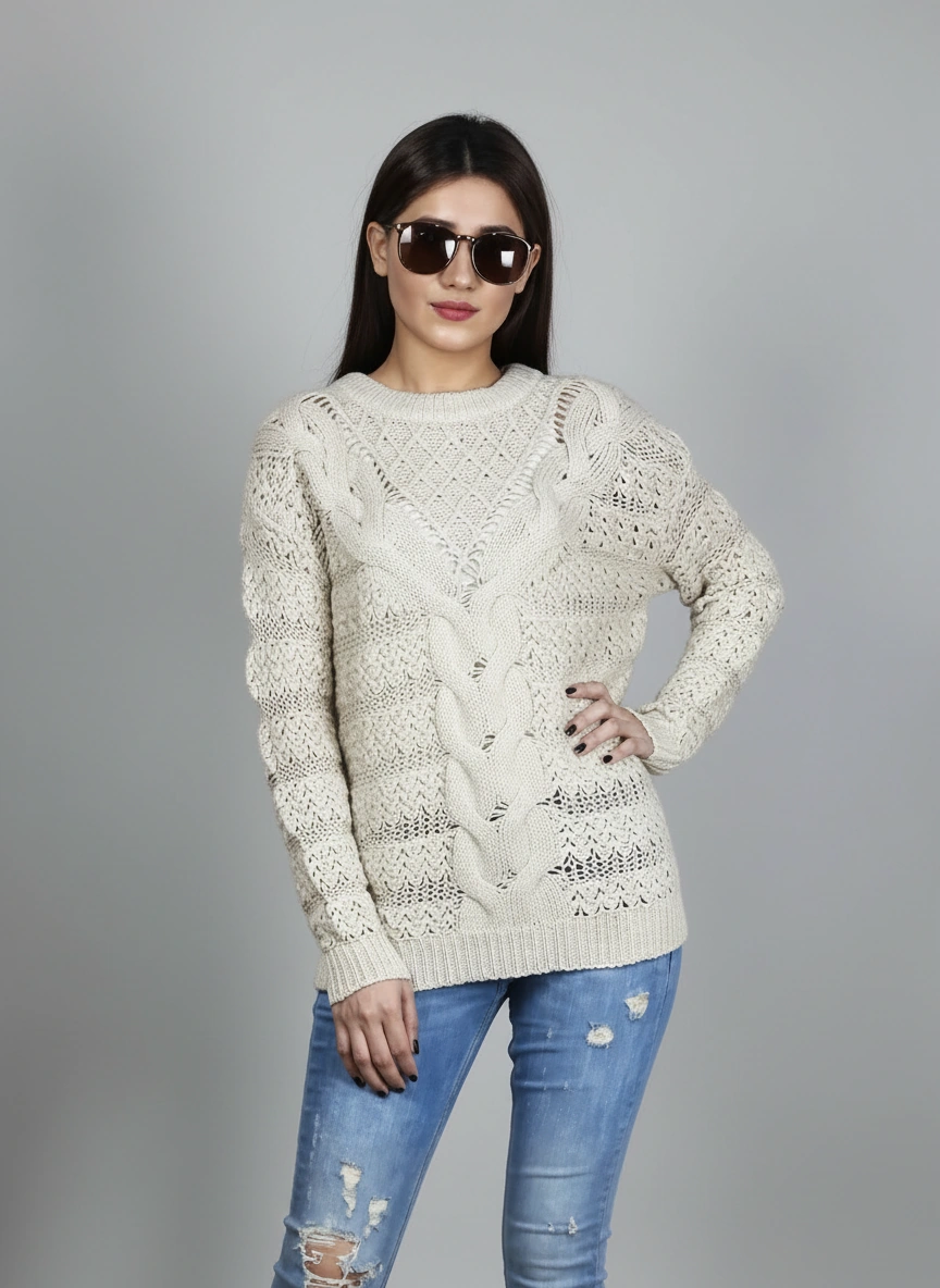 Model wearing Coastline's Ivory Cable Knit Sweater with blue distressed jeans, showing the front cable-knit pattern.