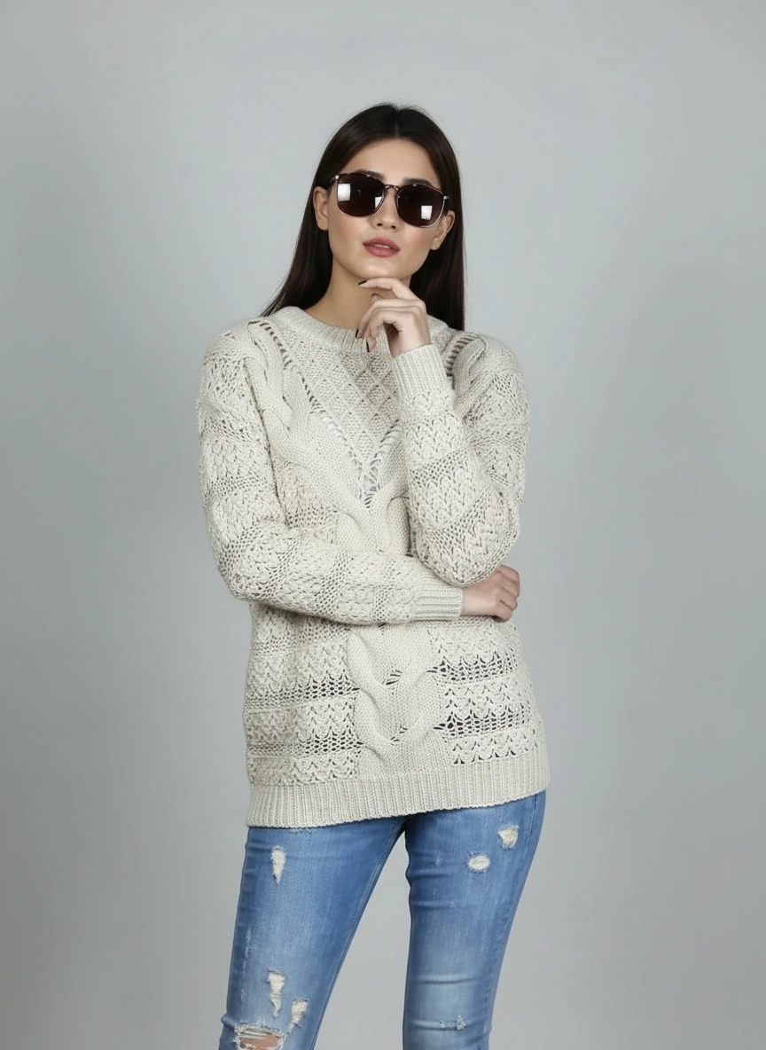 Model wearing Coastline's Ivory Cable Knit Sweater and sunglasses, with one hand near her face.