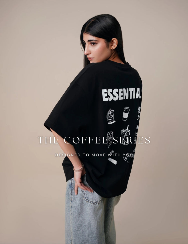 Model wearing Coastline’s oversized black coffee graphic T-shirt, showing the white back print beneath “The Coffee Series” cover text.