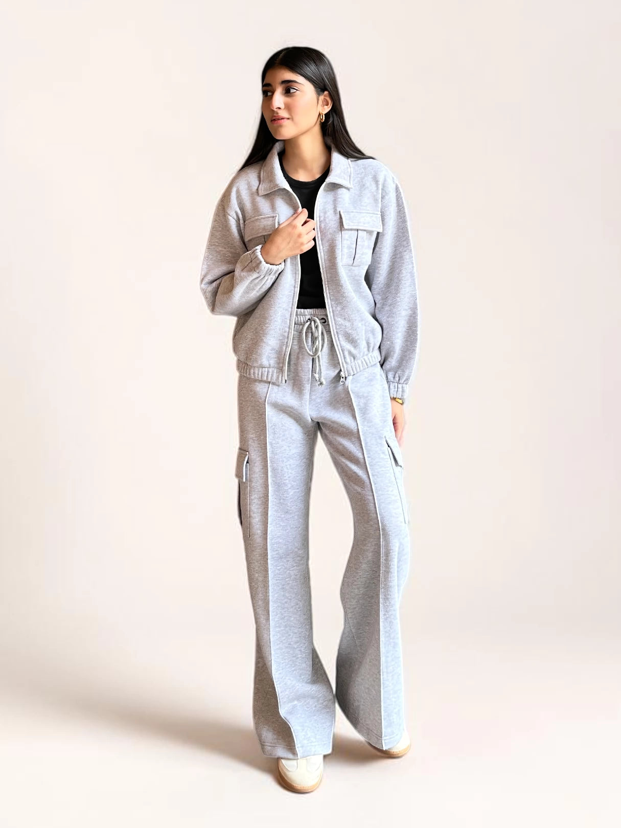 Model wearing Coastline’s heather gray fleece matching set with a collared zip-front jacket, chest pockets and wide-leg cargo trousers.