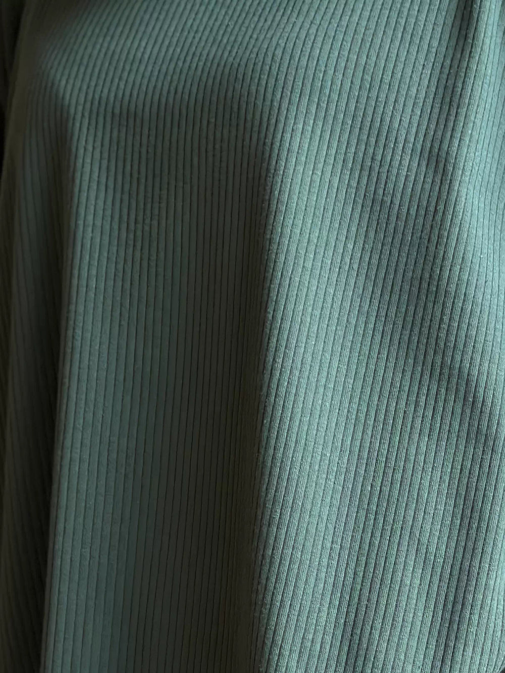 Close-up of the evergreen double-knit fabric on Coastline’s Yula matching set, showing its fine surface texture and soft folds.