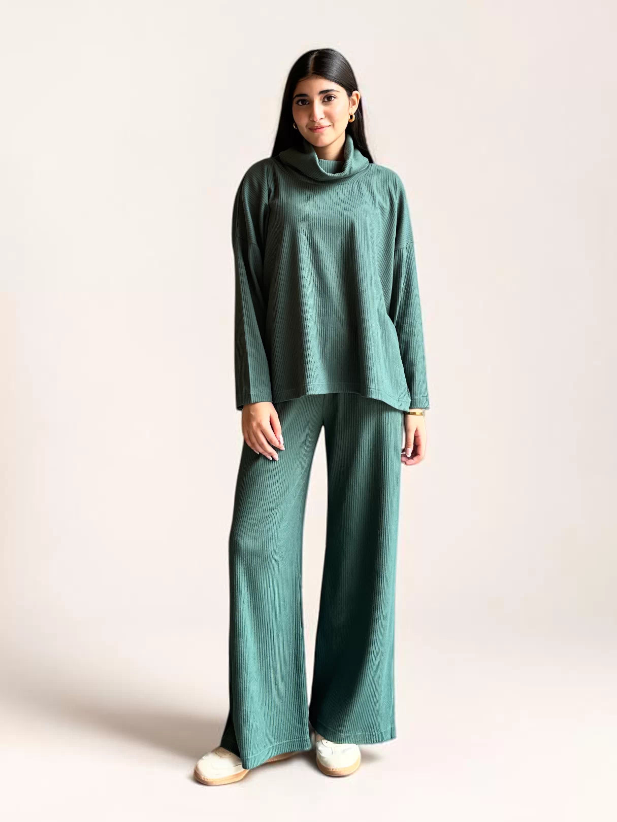Model wearing Coastline’s Yula evergreen double-knit matching set with a high-neck top, long sleeves and wide-leg trousers.