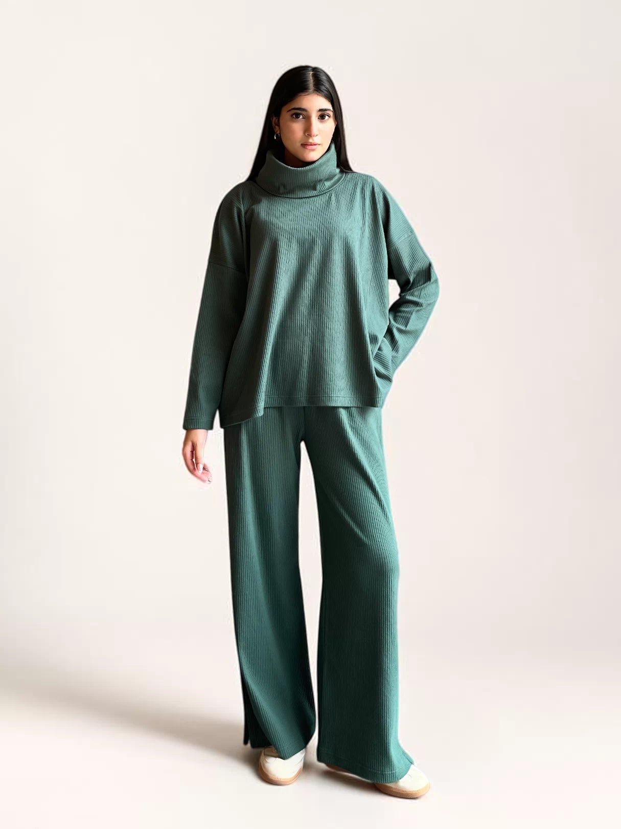Model wearing Coastline’s Yula evergreen matching set with one hand in a trouser pocket, showing the relaxed top and wide-leg fit.
