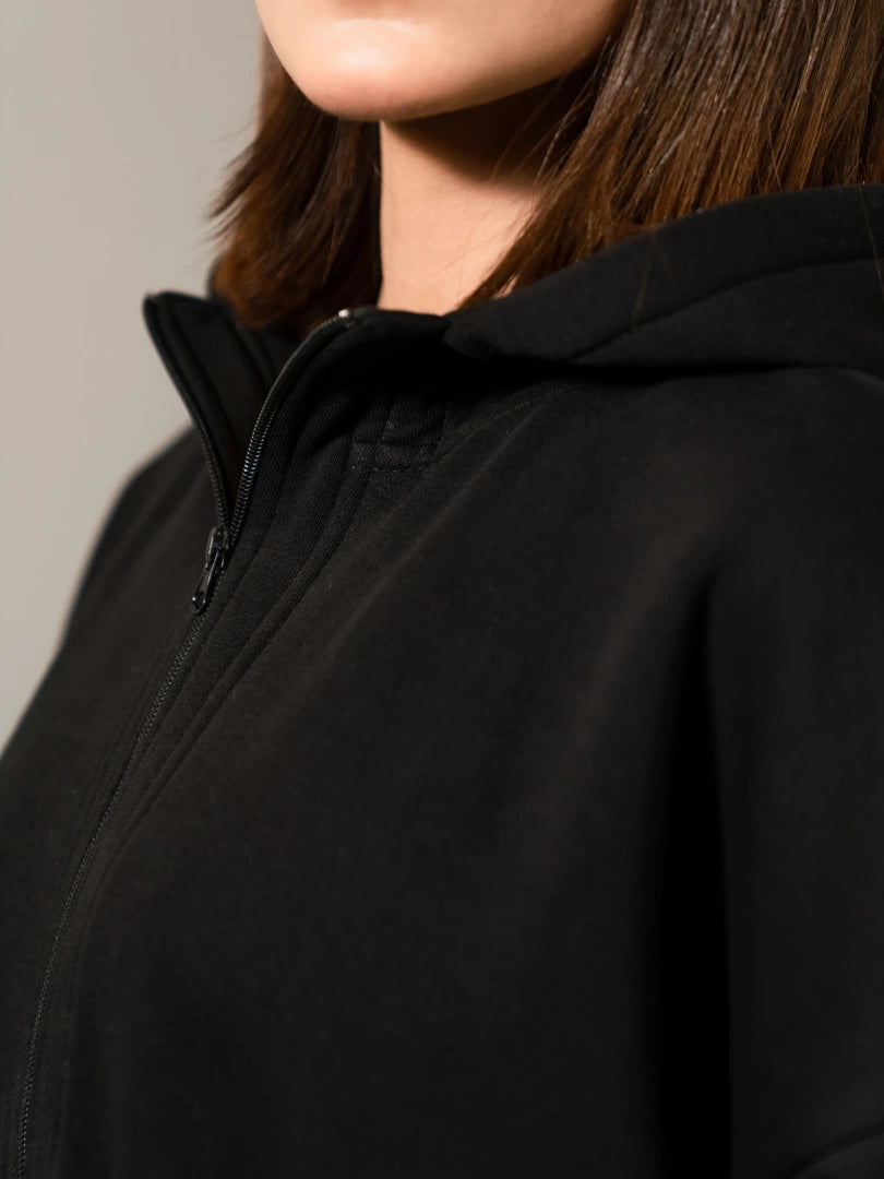Close-up of the Darya black hoodie showing the hood neckline and upper zipper detail.