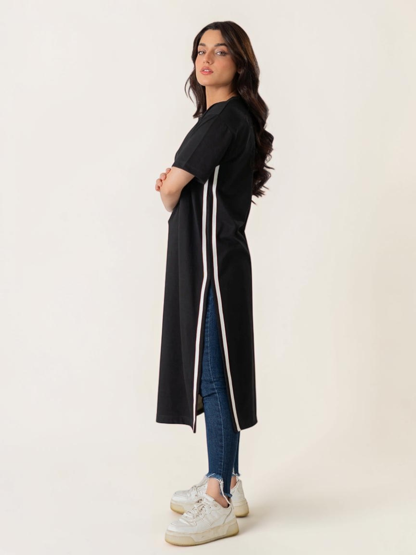 Full-length standing view of the Eve women's black maxi dress, showing its side opening, short sleeves and white contrast trim.