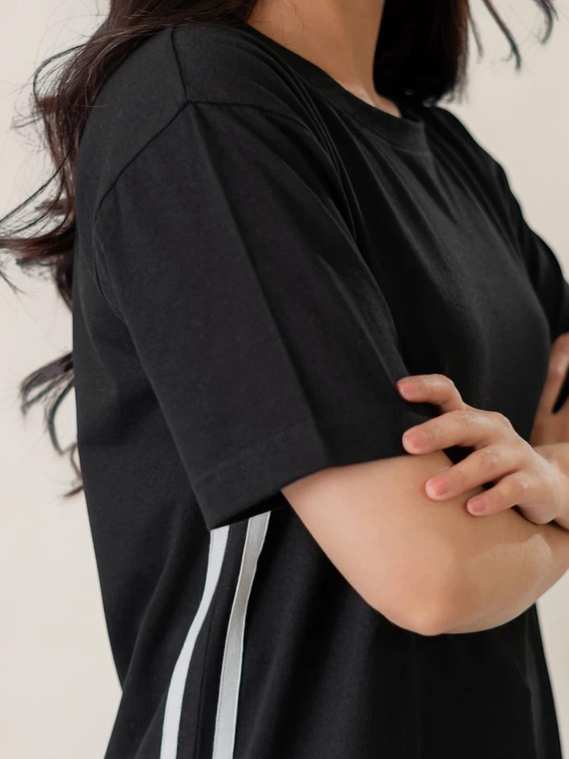 Close-up side view of Coastline's Eve Maxi Dress in Black, highlighting the short sleeve, shoulder seam and smooth fabric drape.