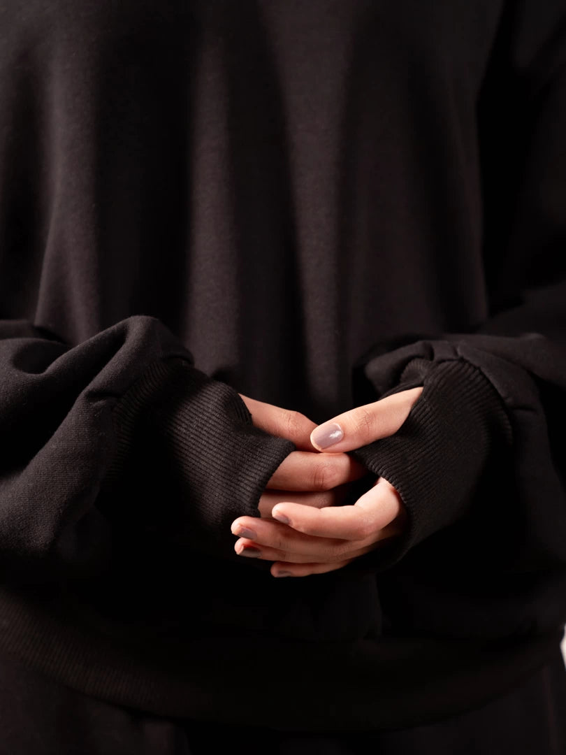 Close-up of the Garconne Black oversized hoodie sleeves featuring thumb holes for added comfort.
