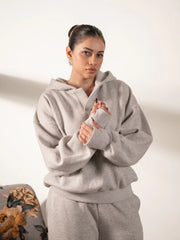 Front view of the Garconne Heather Grey hoodie, showing its oversized sleeves and relaxed fit as the model folds her arms.
