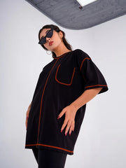 Model wearing Coastline's Goth Drop Oversize Tee in Black, featuring orange contrast stitching, a chest pocket and oversized drop-shoulder fit.
