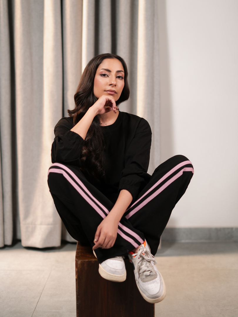Seated model wearing the Indie Black summer co-ord set with a relaxed top and matching striped trousers