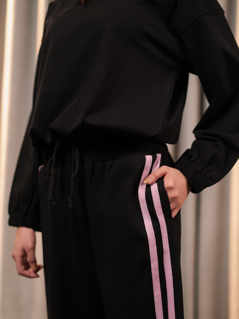 Close-up of Indie Black matching set trousers showing the waistband and contrast side stripes