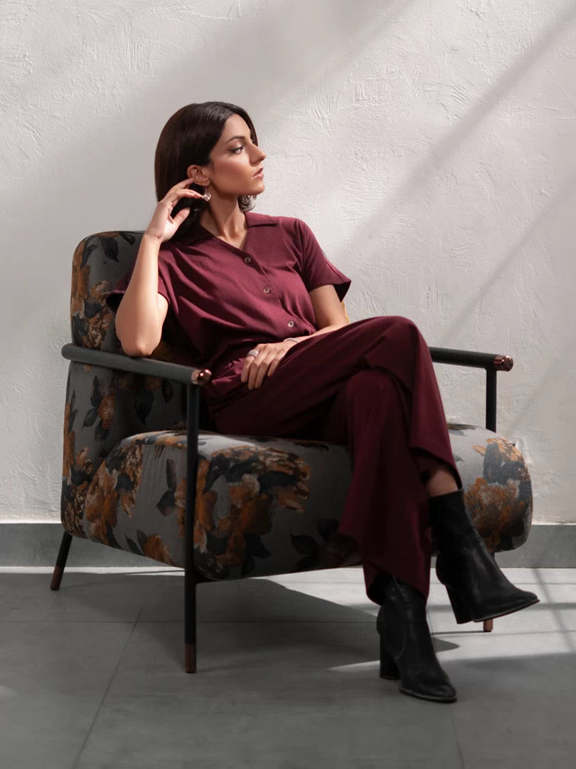 Seated model wearing the Jax Mulberry women's matching set with a button-down top and wide-leg trousers