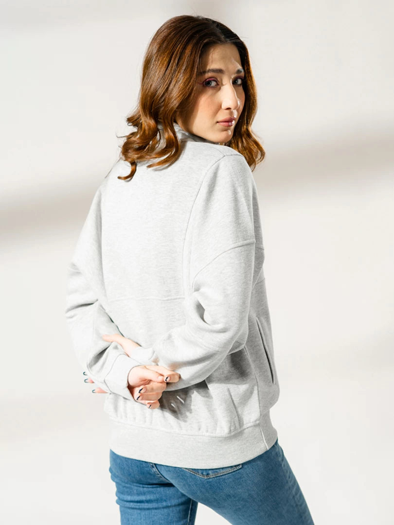 Three-quarter front view of the Kai Heather Grey quarter-zip sweatshirt, showing its standing collar, relaxed sleeves and front pocket.