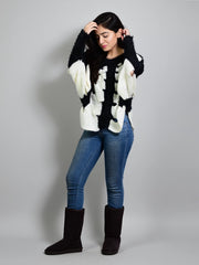 Model posing with her hands near her hair while wearing Coastline's Kate Fuzzy Sweater in Black and White.