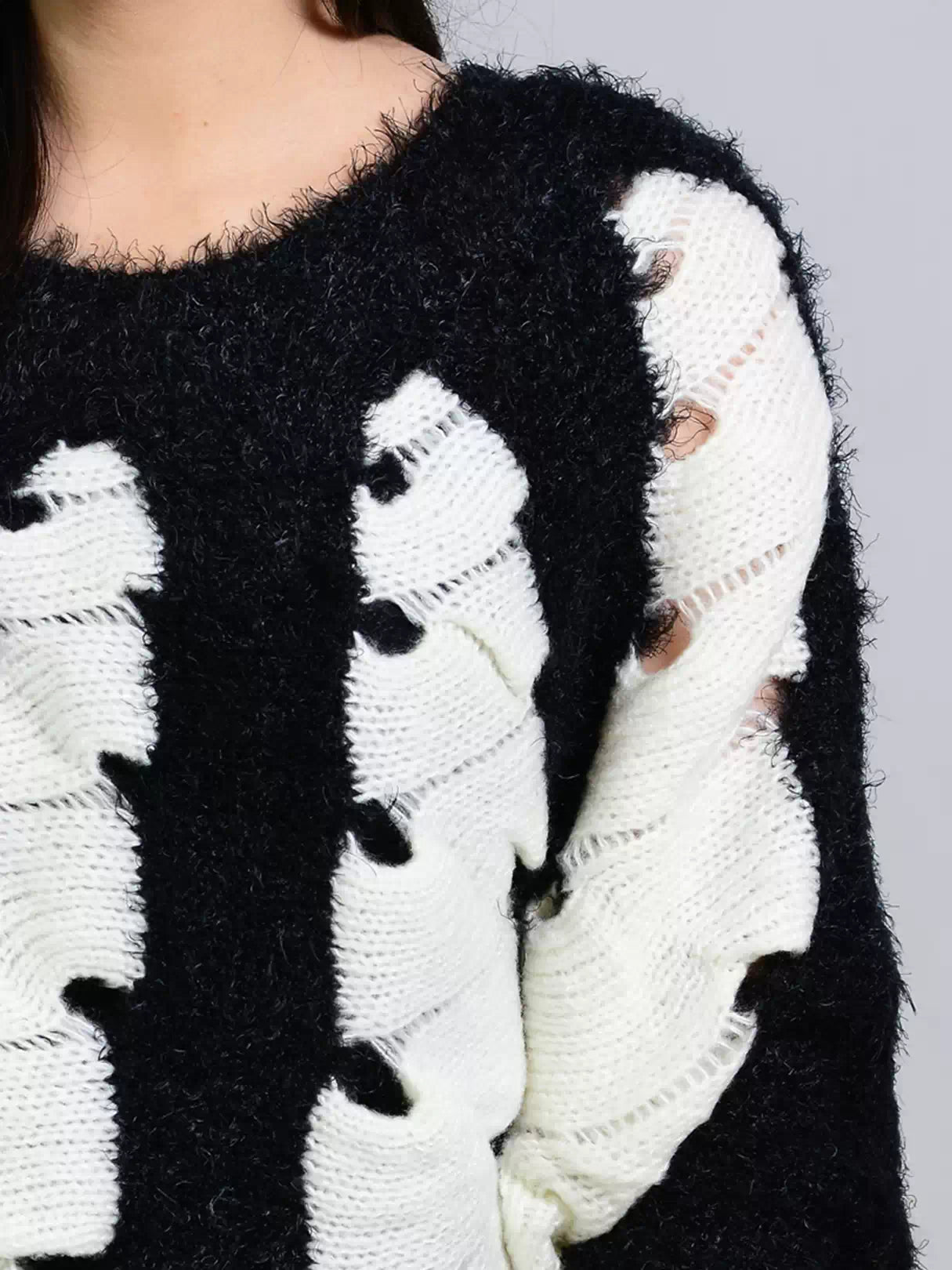 Close-up of Coastline's Kate Fuzzy Sweater showing its textured black and white knit pattern.