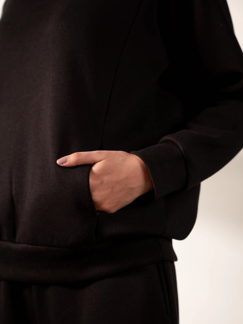 Close-up of the Lana Black sweatshirt showing its side pocket and panel detailing