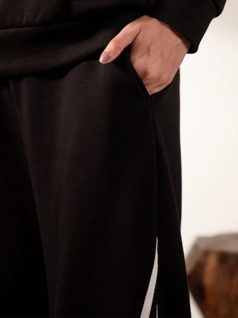 Close-up of the Lana Black trousers showing the side pocket, with one hand placed inside.
