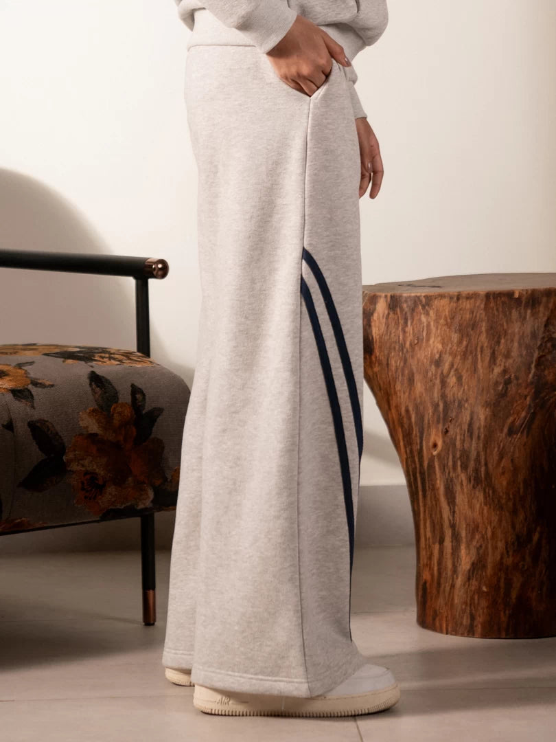 Side view of the Lana grey fleece trousers showing the wide-leg silhouette and contrast stripe detail.