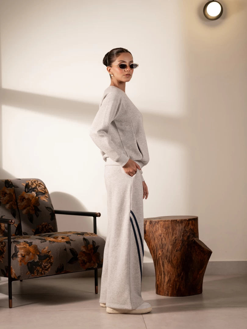 Full-length side view of the Lana Heather Grey winter co-ord set showing the sweatshirt and wide-leg striped trousers.