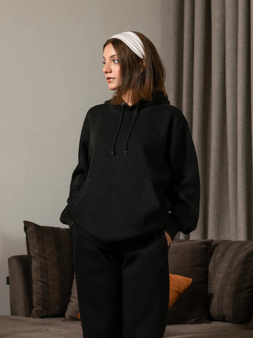 Model wearing the Lynn oversized winter hoodie in Black with her hands in the pockets, displaying its loose silhouette and casual fit.