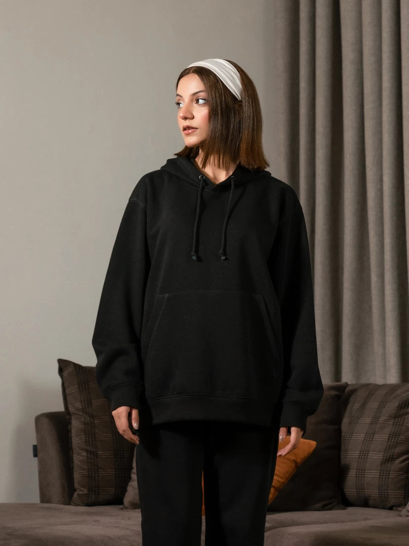 Three-quarter view of the Lynn Essential women's Black hoodie, highlighting its roomy sleeves, hood and relaxed body.